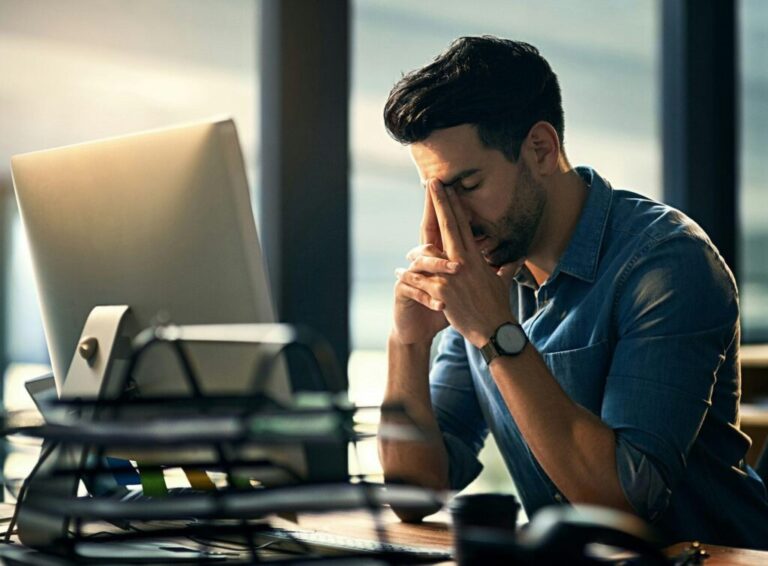 Shot of a young businessman experiencing stress during a late night at work