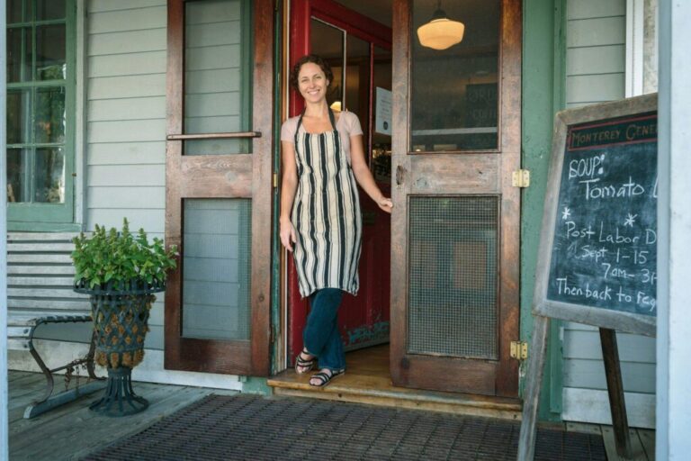 Female shop assistant in doorway of country store