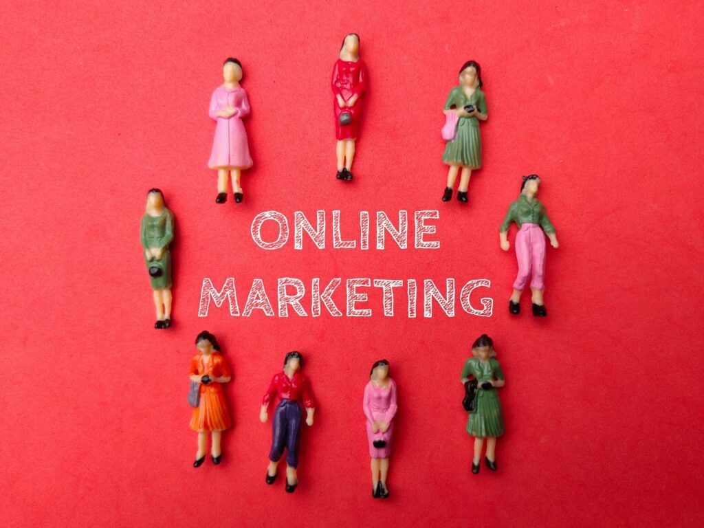 Miniature businesswomen with the word ONLINE MARKETING