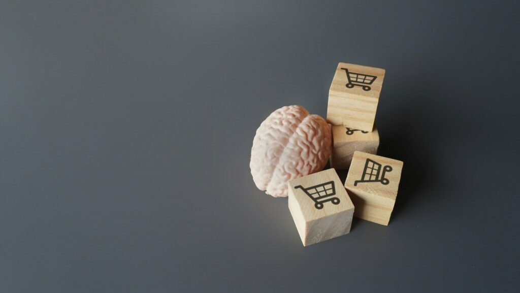 A human brain and wooden blocks with shopping carts icon.