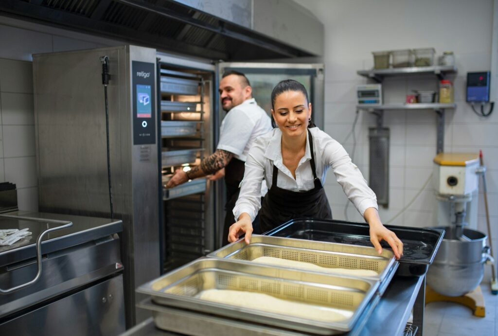 Chef and cook working on their dishes indoors in restaurant kitchen