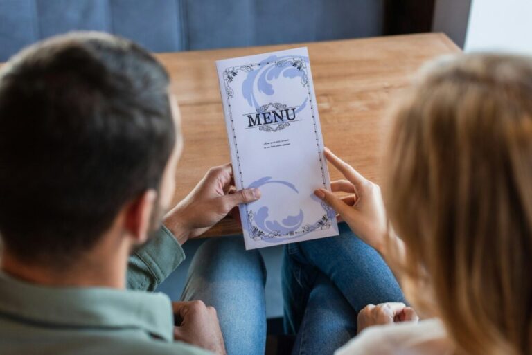 back view of blurred couple holding menu in restaurant