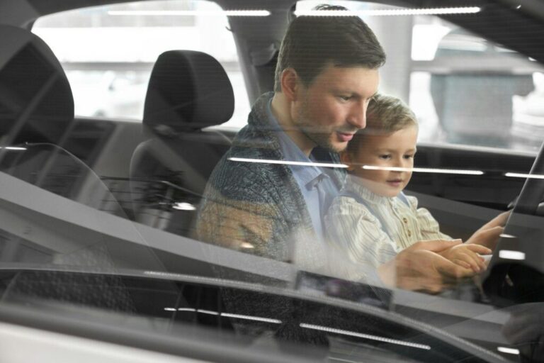 Potential buyer of car testing car with son