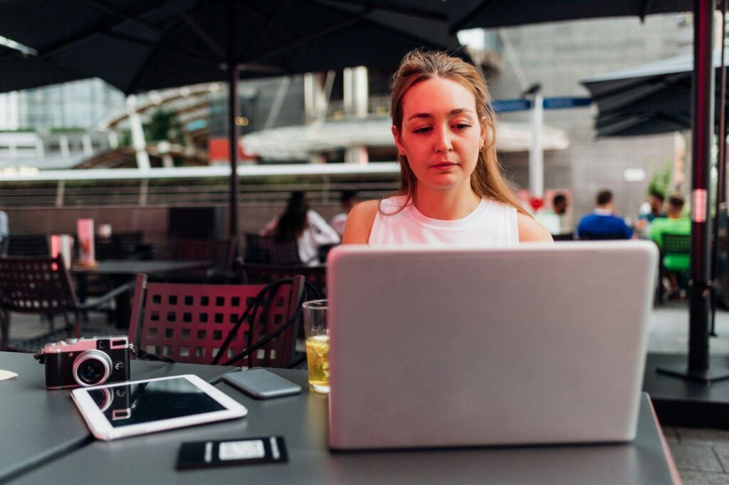 Young business woman digital nomad freelance blogger outdoors working using computer