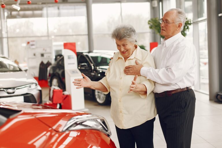 Elegant old couple in a car salon