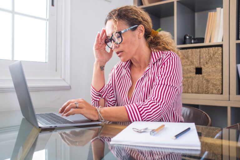 Exhausted female executive holding head in hand feeling lack of energy motivation