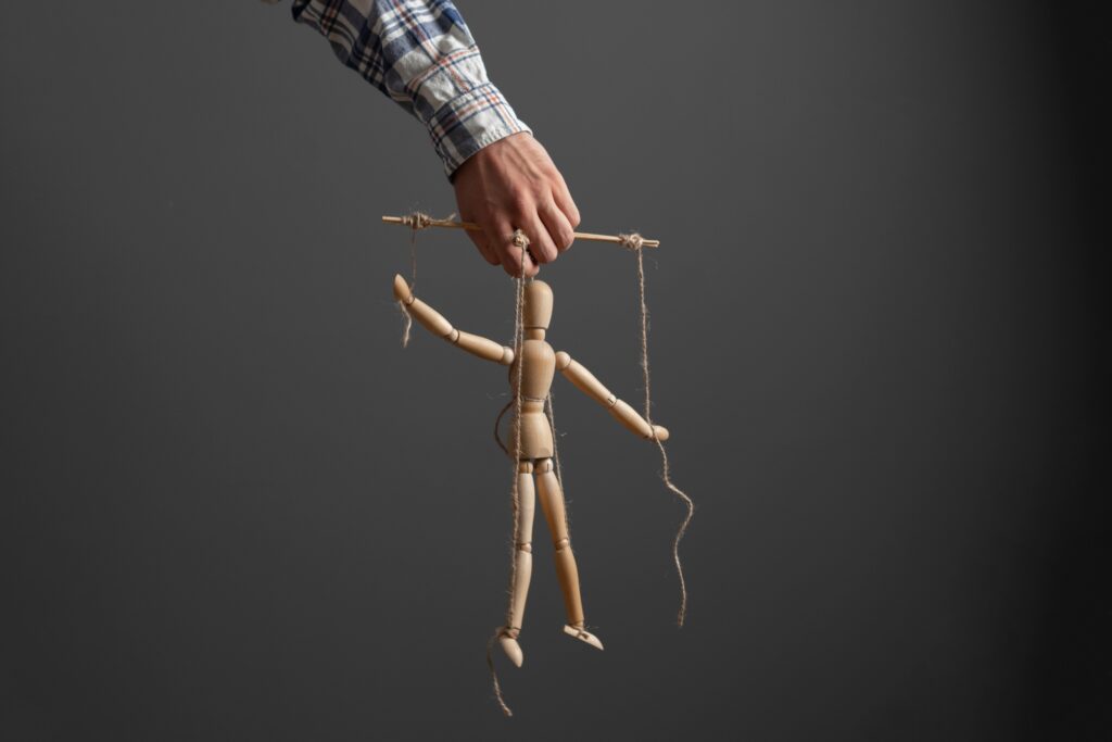 the emploee holding a marionette wooden doll, manipulation concept