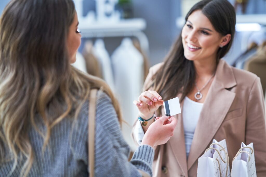 Woman seller and buyer in clothes store