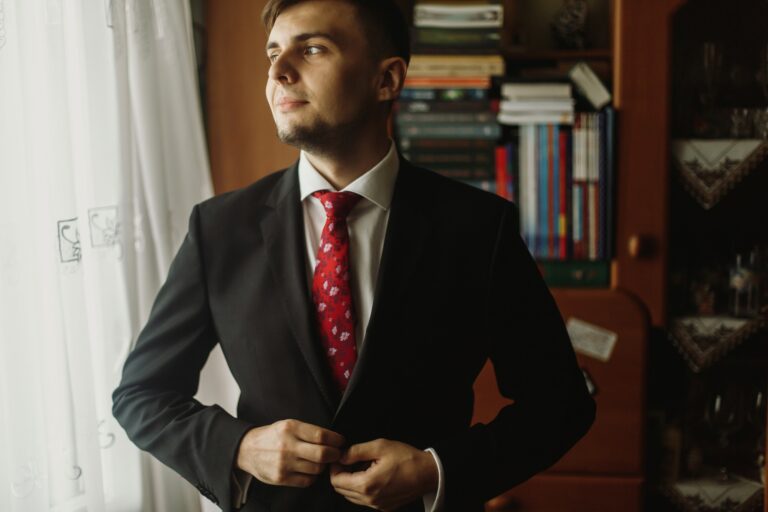 Cégvezetőként ezt tanuld Barney Stinsontól Handsome groom in white shirt with red tie buttoning up black suit